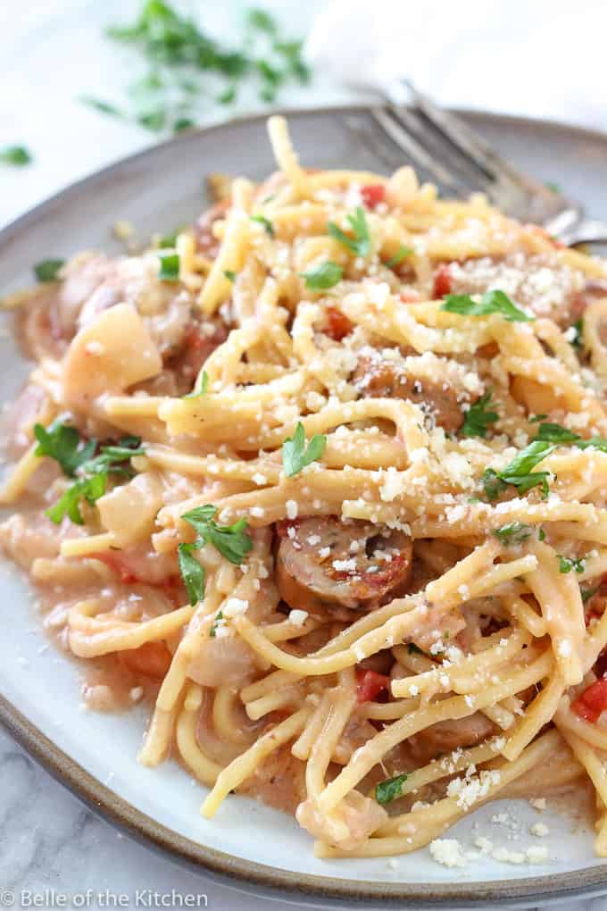 A close up of a plate of pasta with sausage