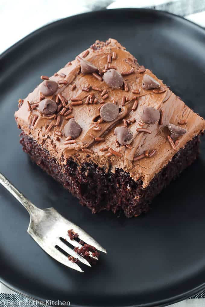 aerial shot of a black plate with a fork and slice of chocolate cake