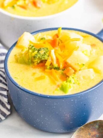 a blue bowl of broccoli cheese soup
