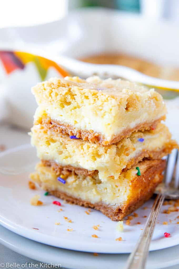A close up of a stack of cheesecake bars with sprinkles