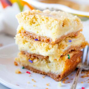 A close up of a stack of cheesecake bars with sprinkles