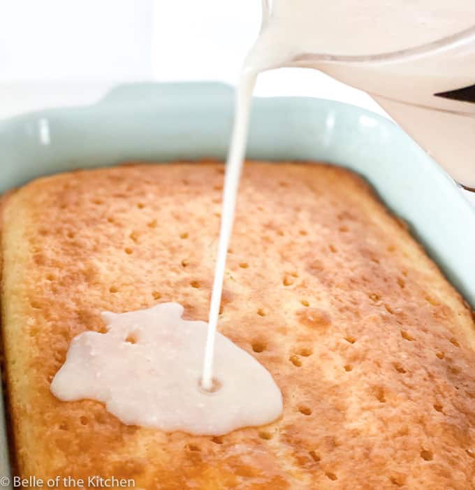 milk being poured over a cake