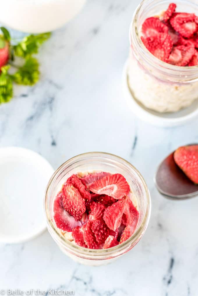 mason jars full of oatmeal and strawberries