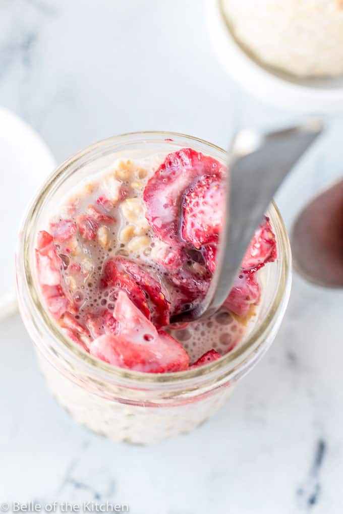 a mason jar full overnight oats and strawberries