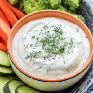 greek yogurt ranch dip in a bowl with veggies around it