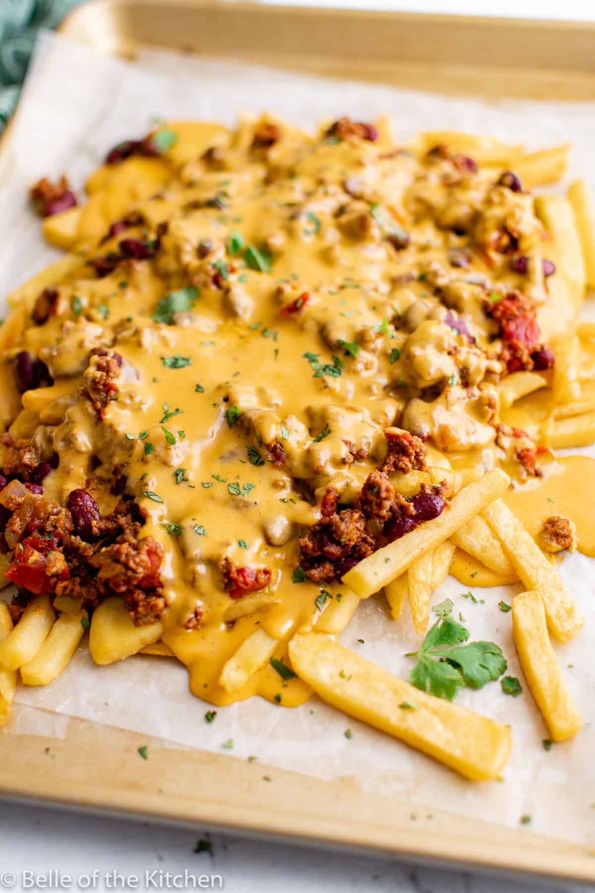 fries covered with chili and cheese sauce on a sheet pan