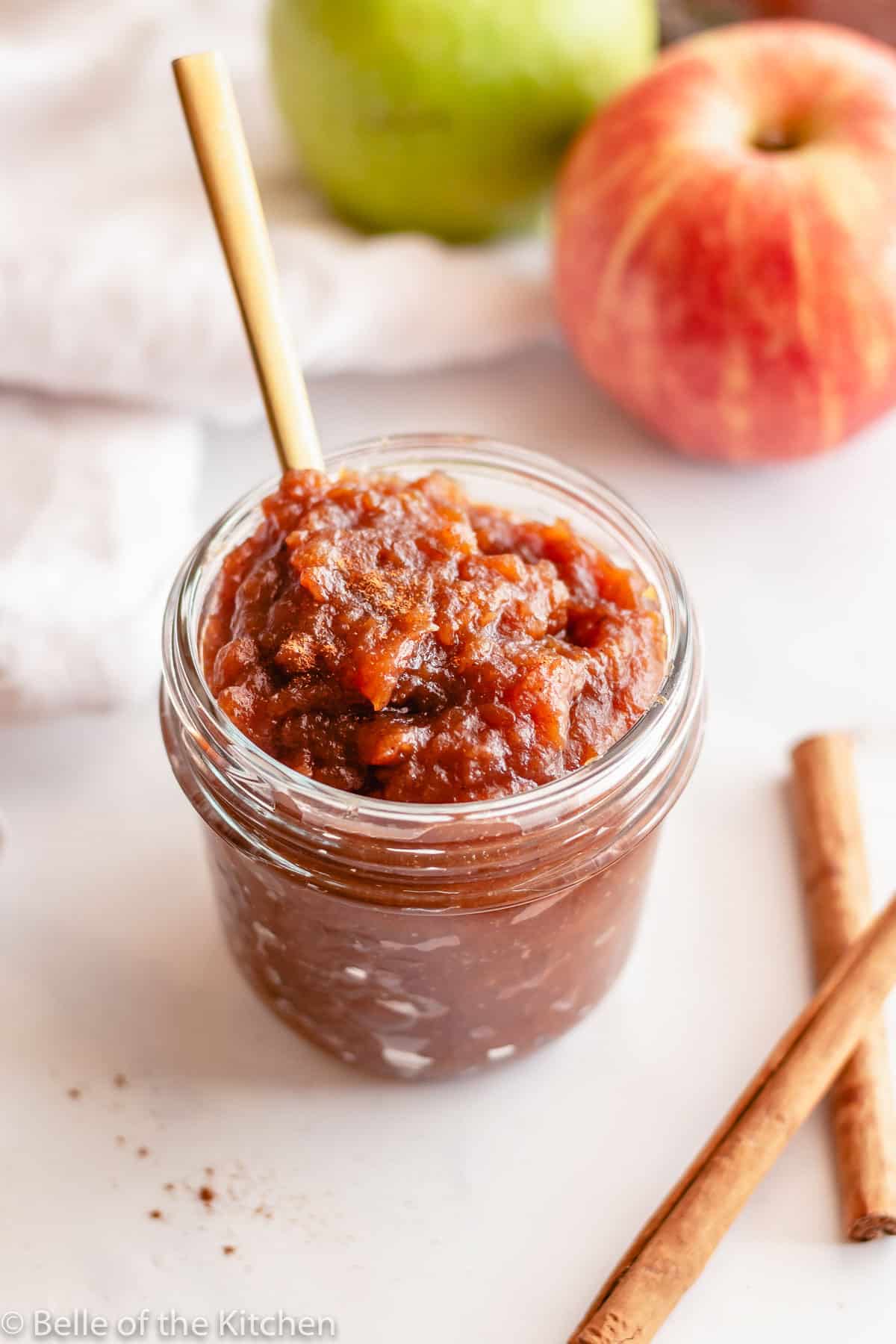 instant pot apple butter in a glass jar with a spoon