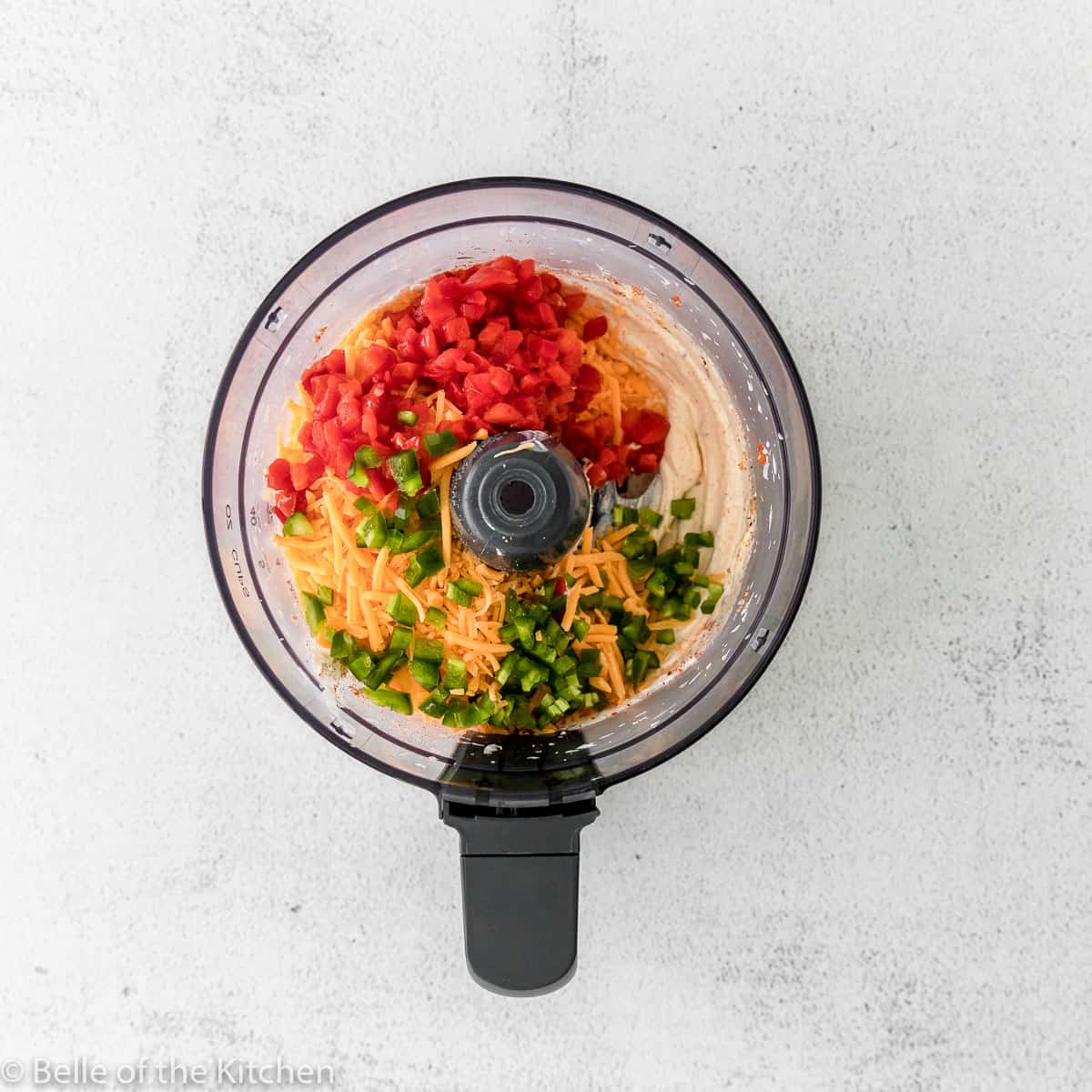 a food processor with pimentos, cheese, and jalapeños 