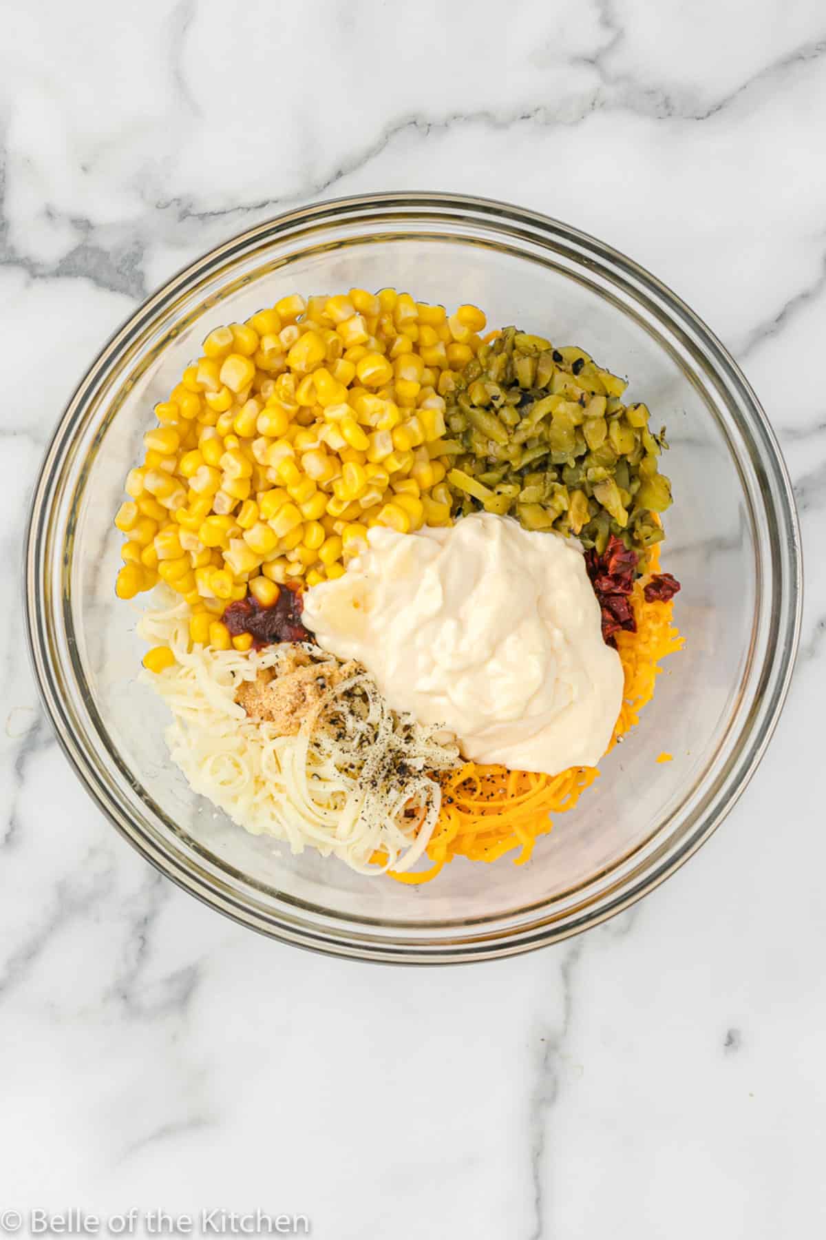 corn, green chiles, mayo, and cheese in a glass bowl