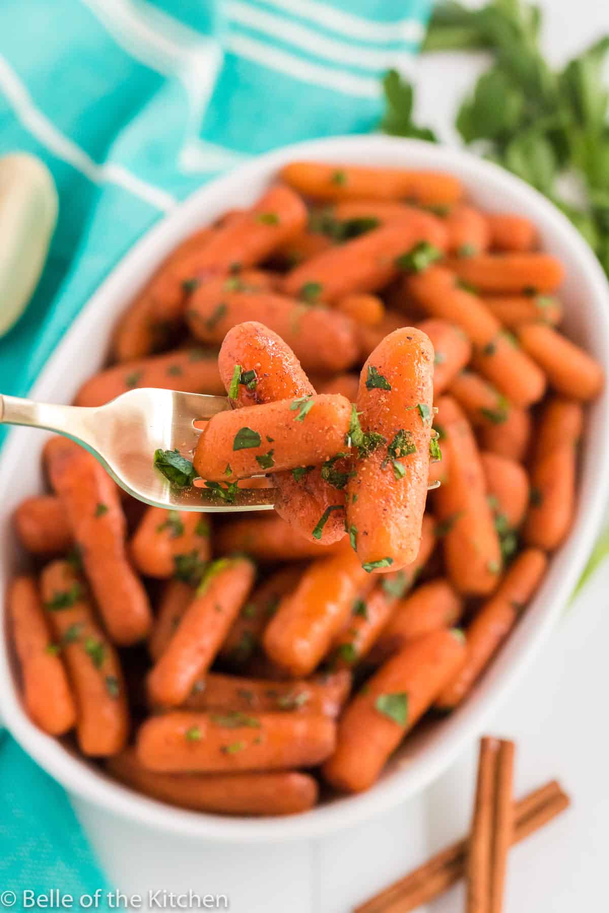 a gold fork digging into a bowl of carrots