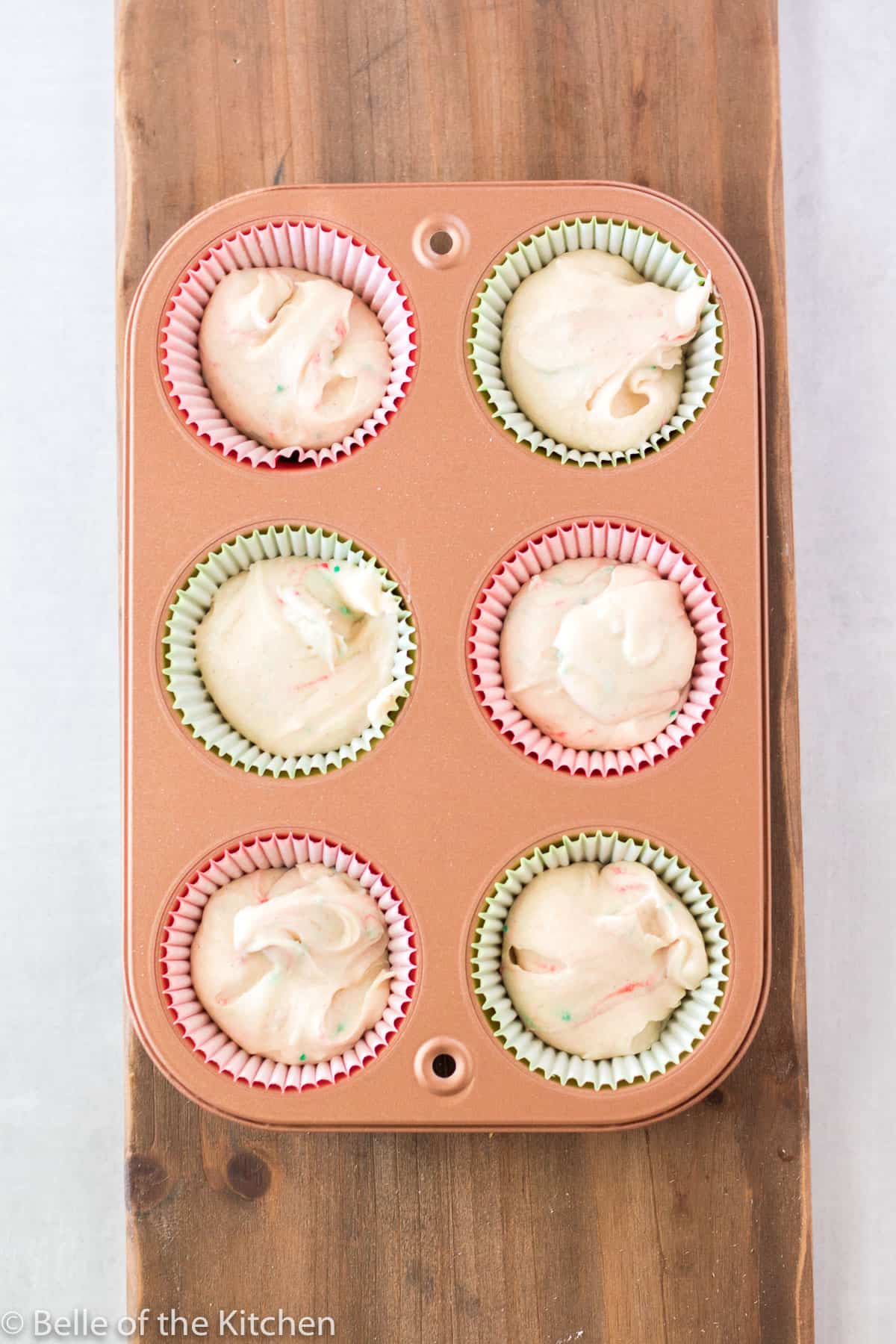 a cupcake pan with liners full of batter