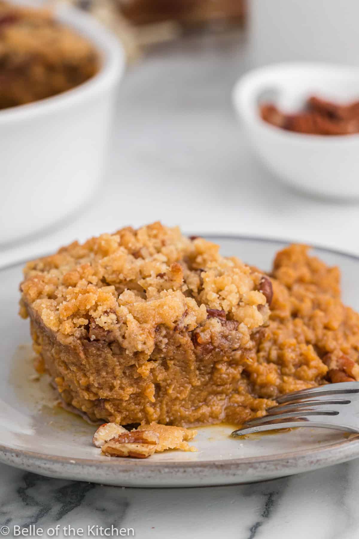 a casserole of sweet potatoes and pecan on a plate with a fork