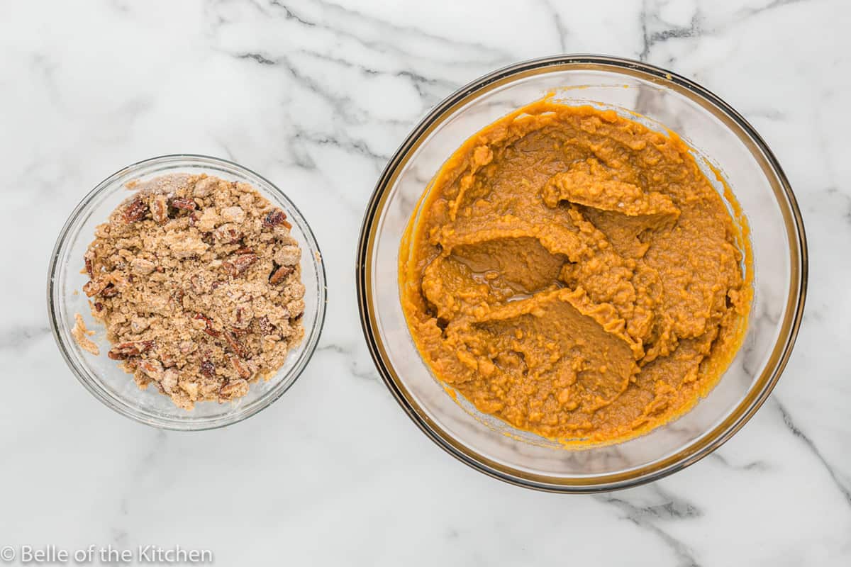 a bowl of mashed sweet potatoes next to a bowl of pecans