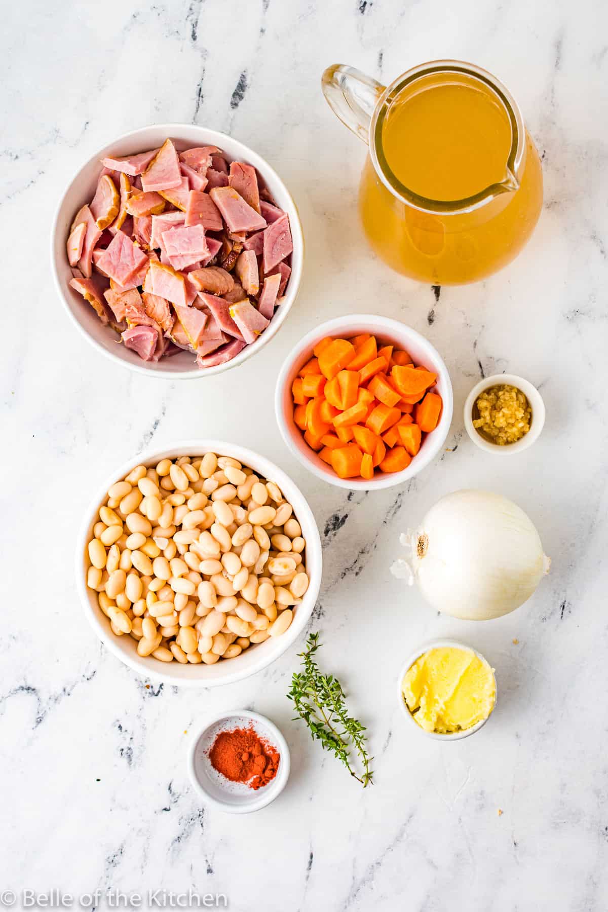 bowls of carrots, onions, chicken broth, beans, garlic, and ham