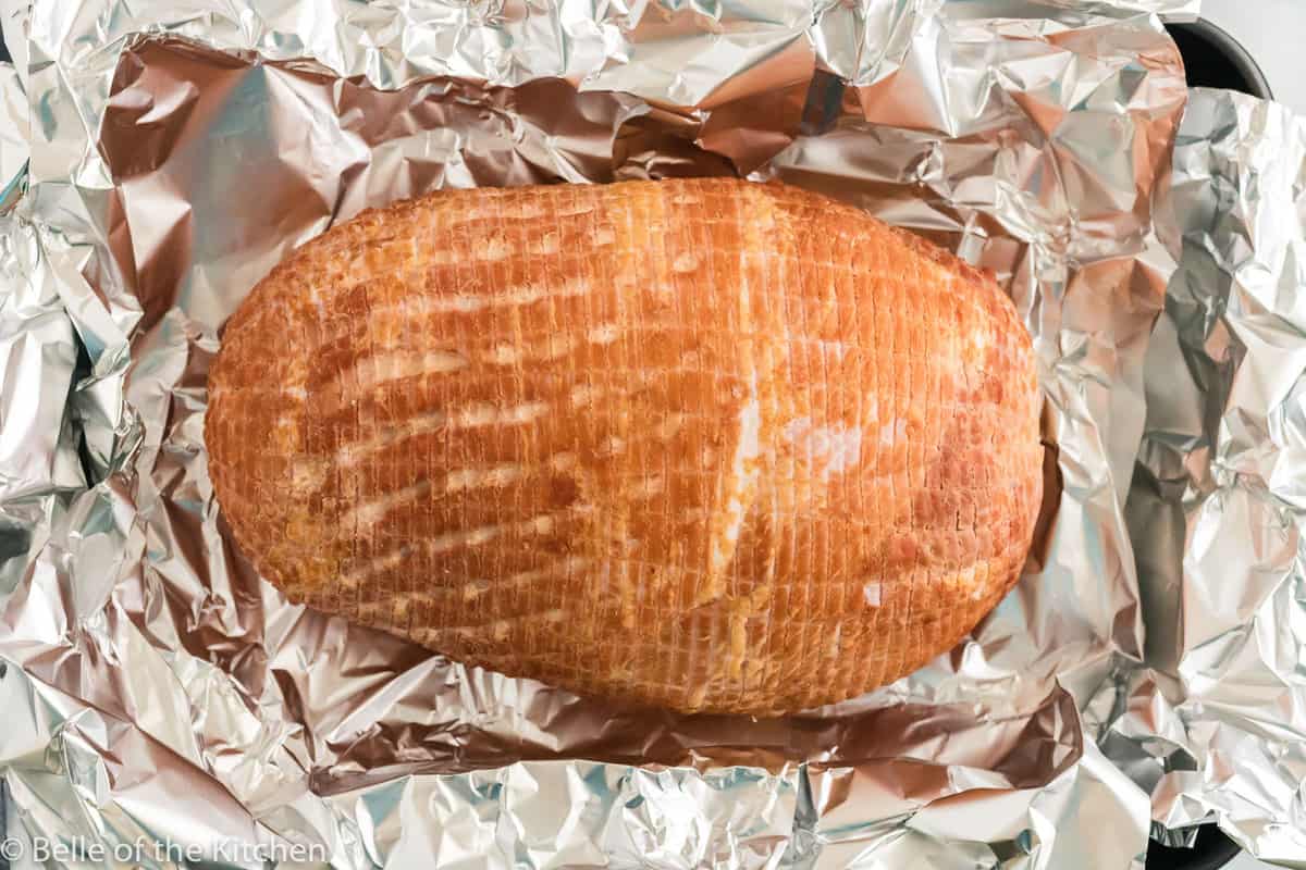 a sliced ham on aluminum foil