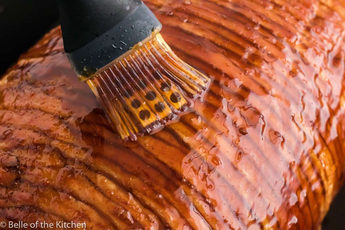 maple glaze being brushed onto ham