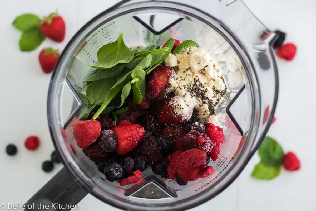 a blender full of berries, spinach, and yogurt