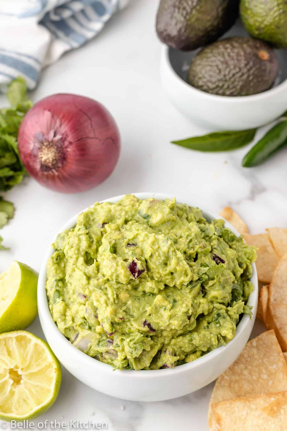 chips and limes next to a bowl of copycat Chipotle guacamole