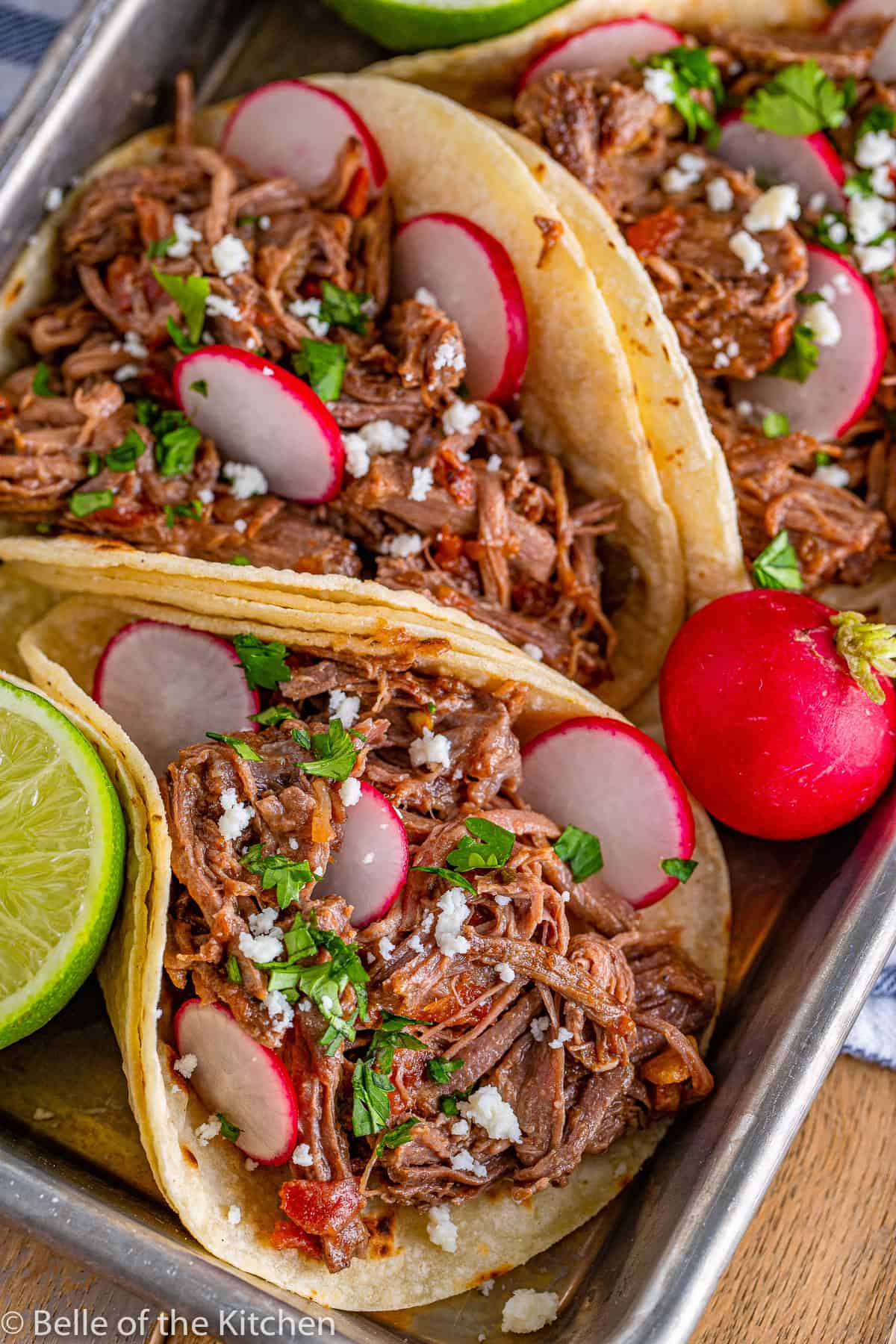 beef tacos on a tray with radishes