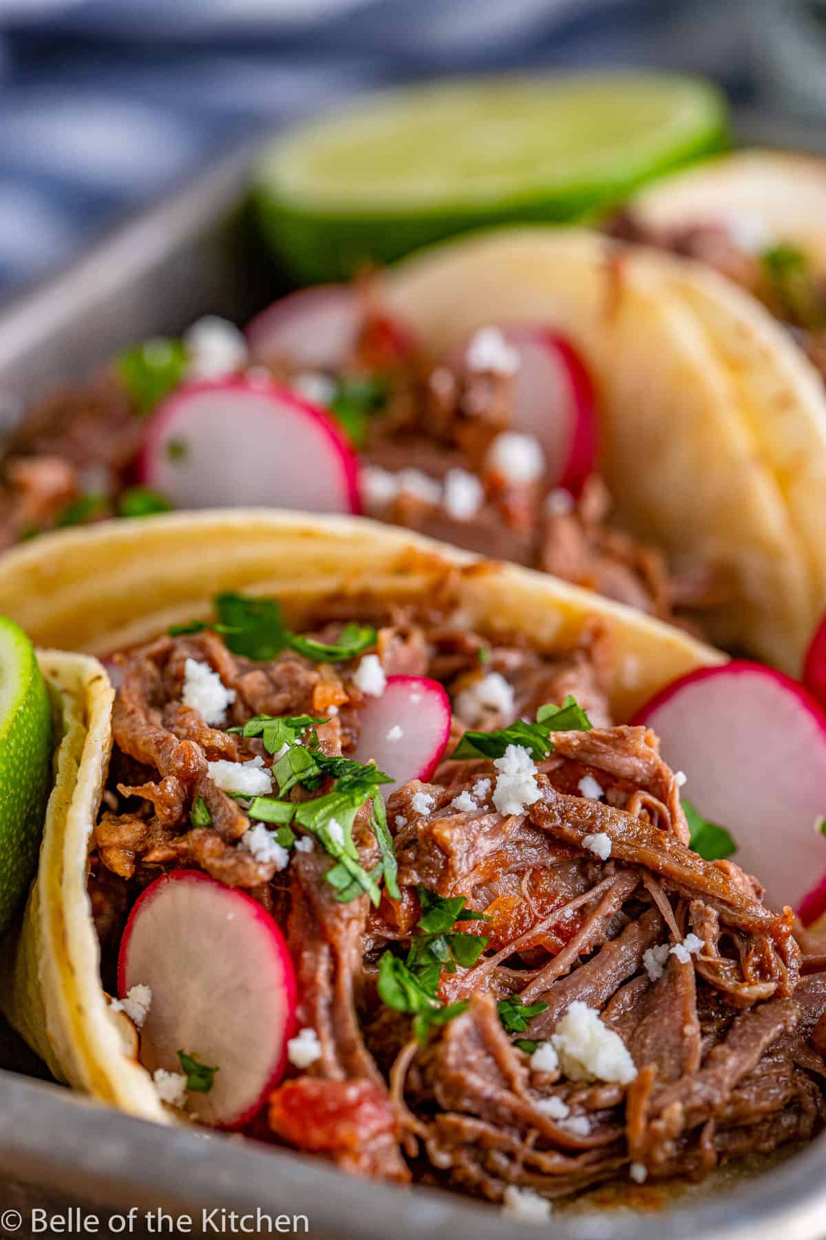 beef tacos on a tray with radishes