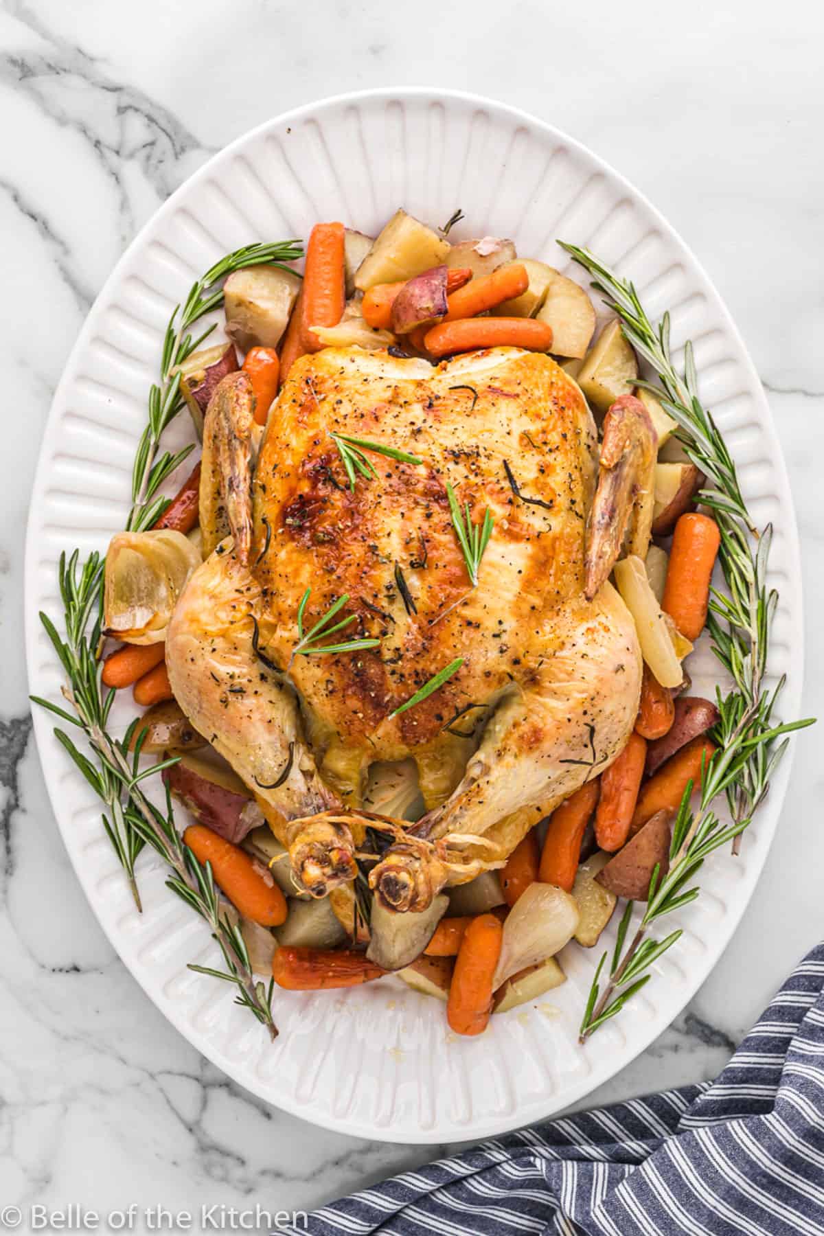 a whole roasted chicken on top of vegetables