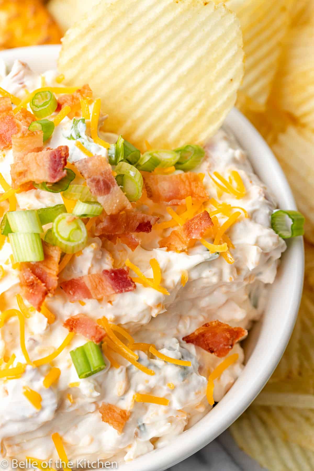 a dip topped with bacon and green onions