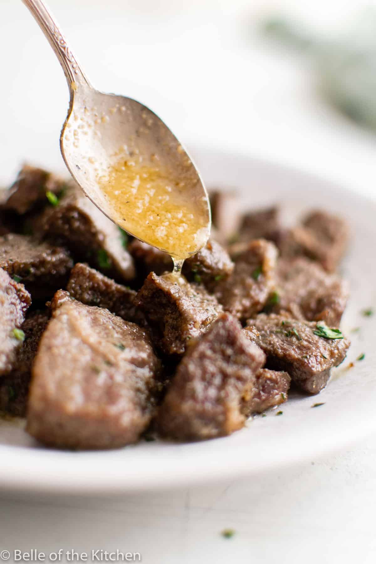 a spoon dripping butter over meat