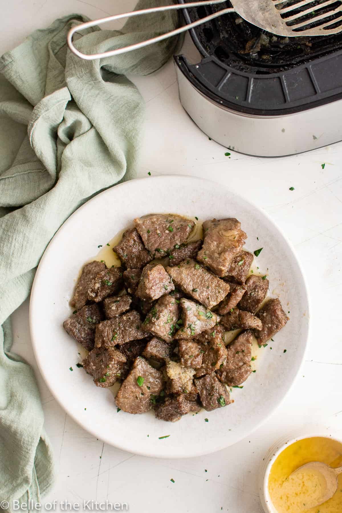 a white plate with chopped steak bites