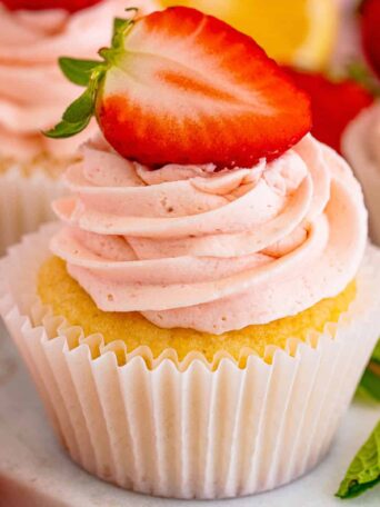 a strawberry lemon cupcake next to mint leaves