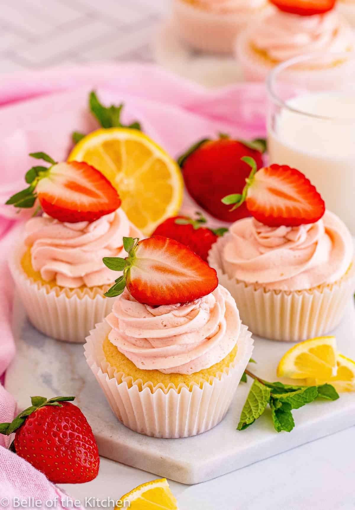 cupcakes with pink frosting and strawberries on top