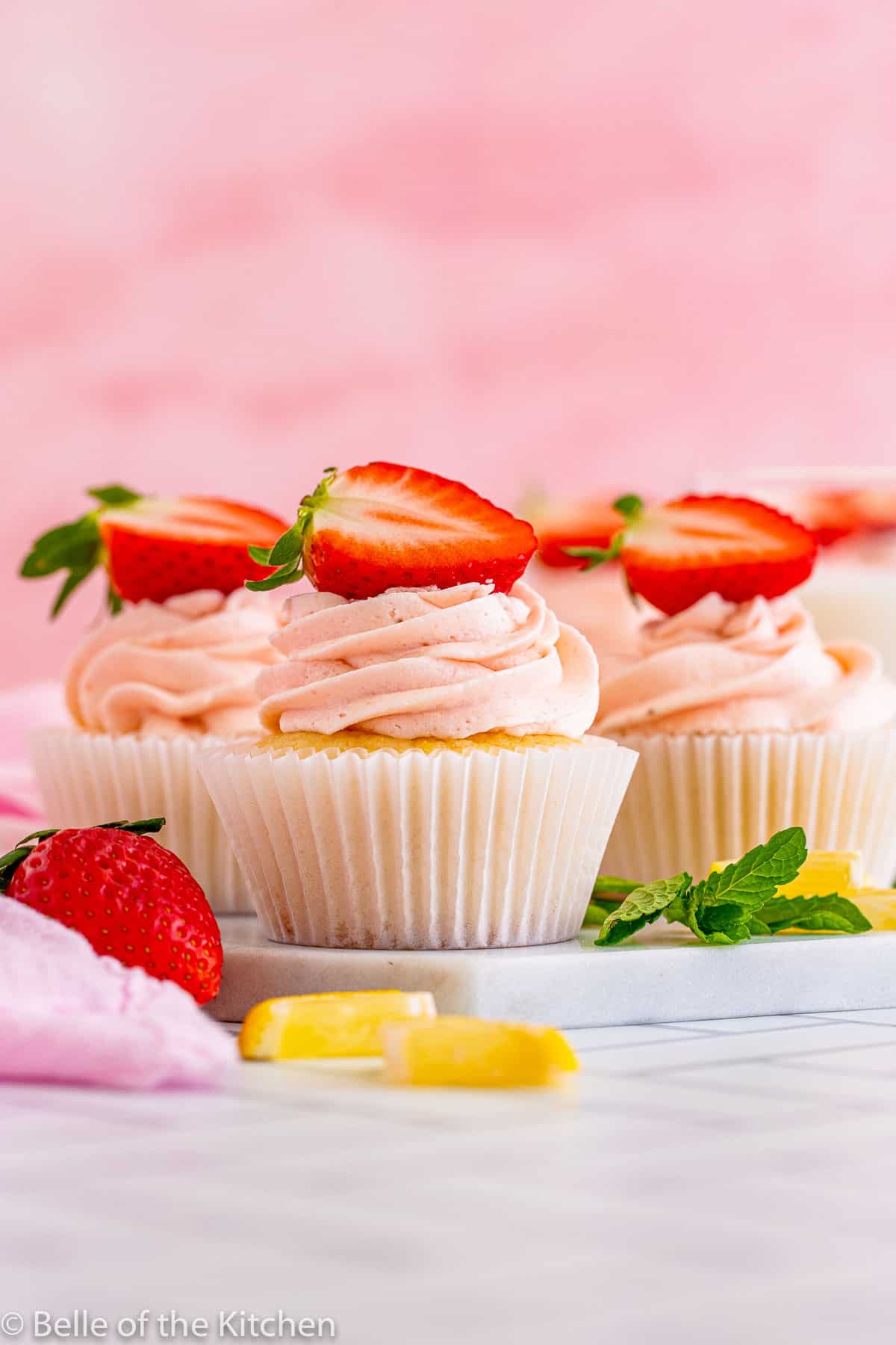 cupcakes with pink frosting and strawberries on top