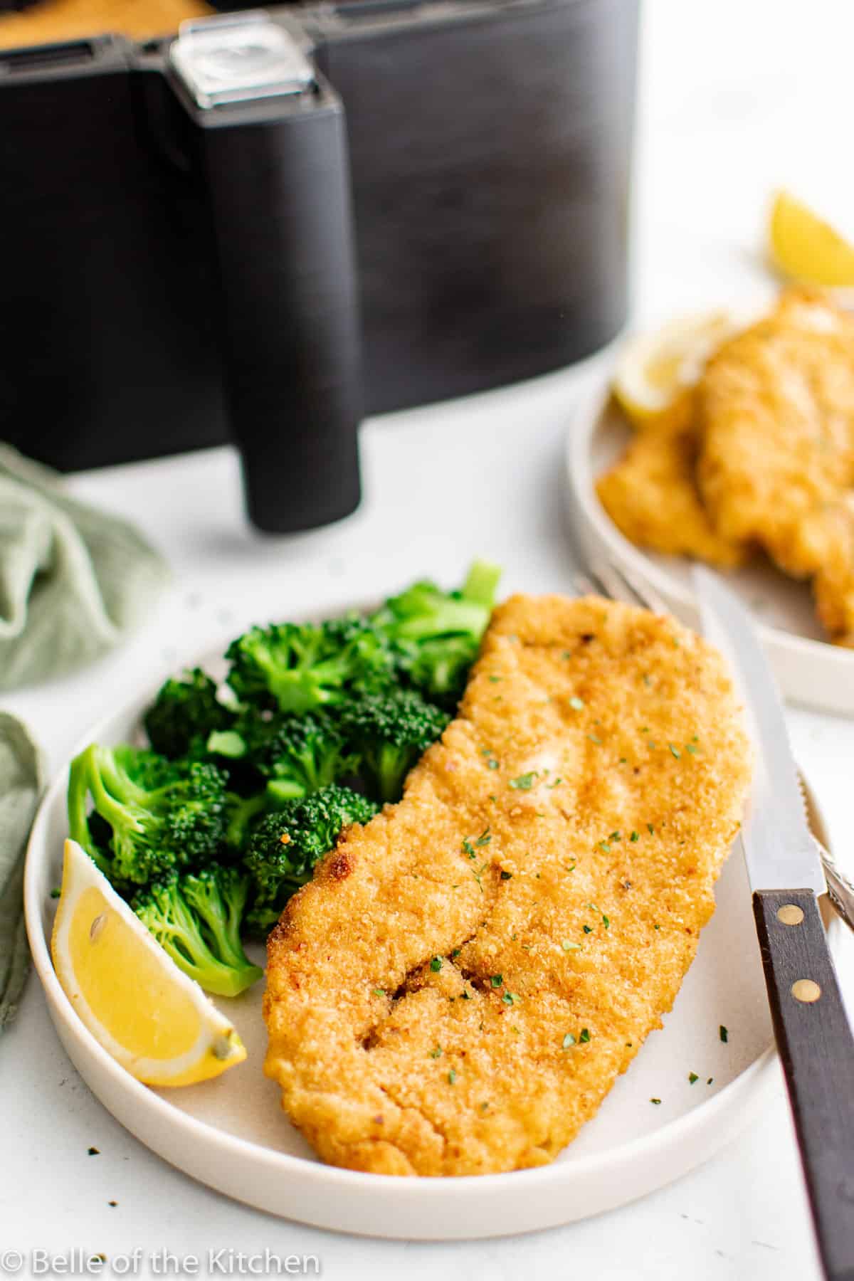 a breaded chicken cutlet and broccoli on a plate