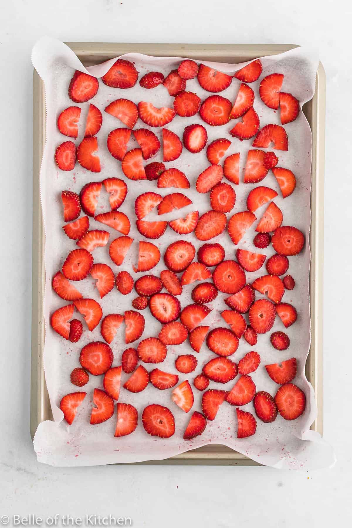 sliced strawberries on a sheet pan.