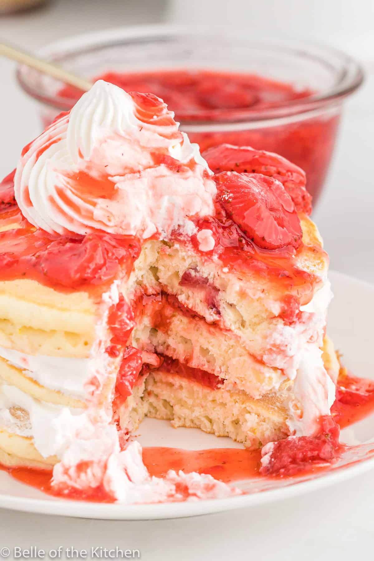 a stack of pancakes with whipped cream on top