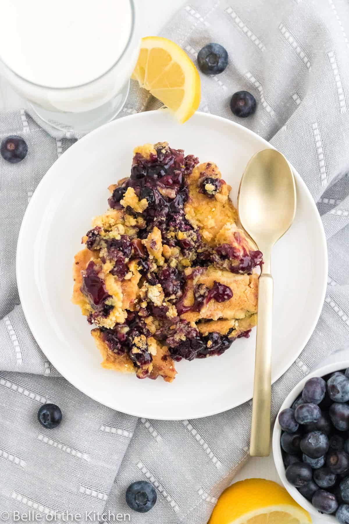a plate of blueberry cobbler with a spoon.
