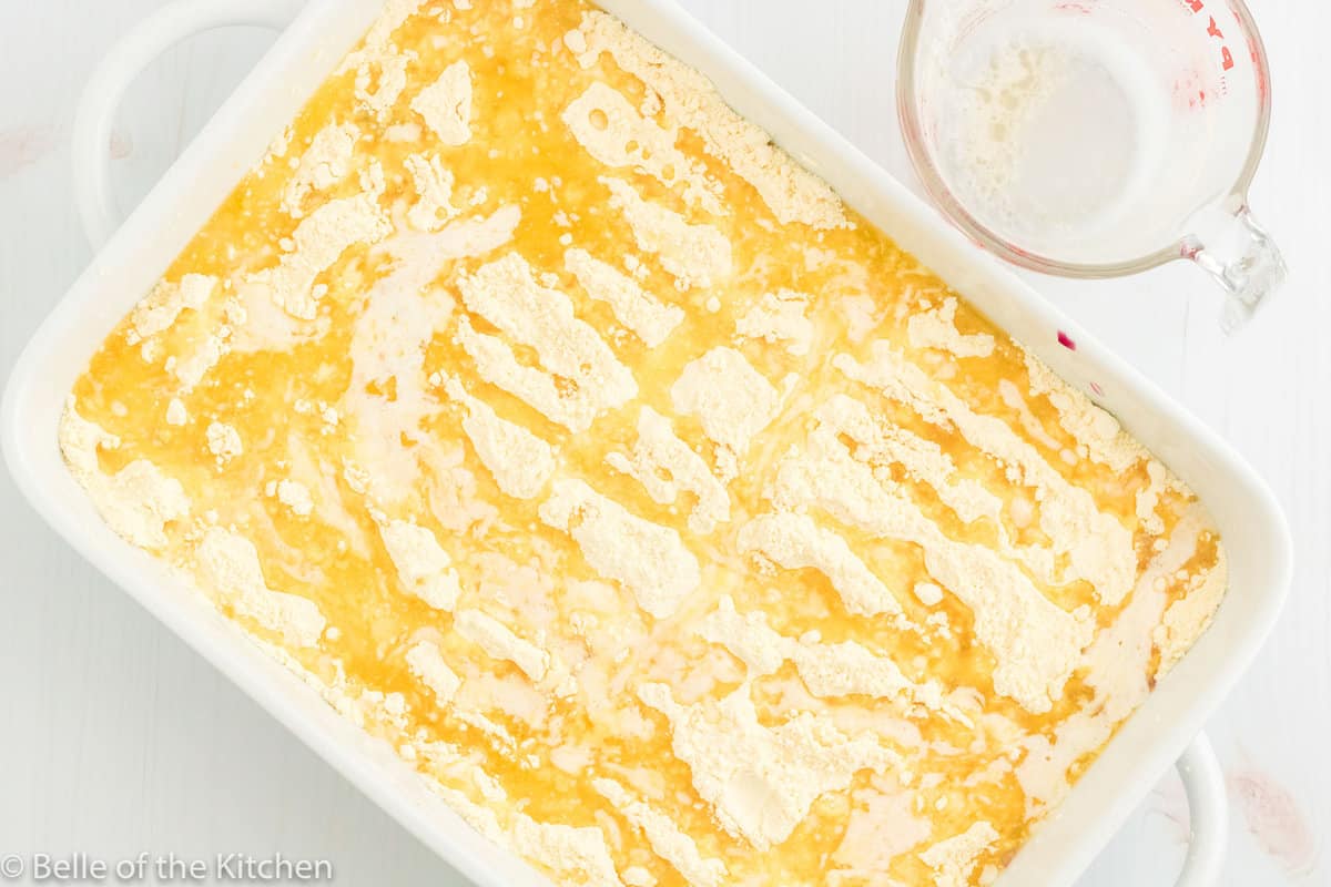 melted butter spread on top of a cake in a baking dish.