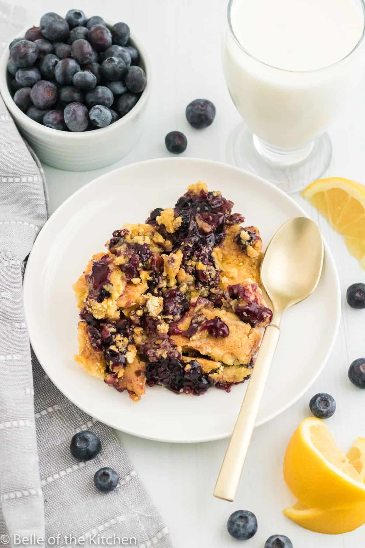 a plate of blueberry dump cake with a spoon.