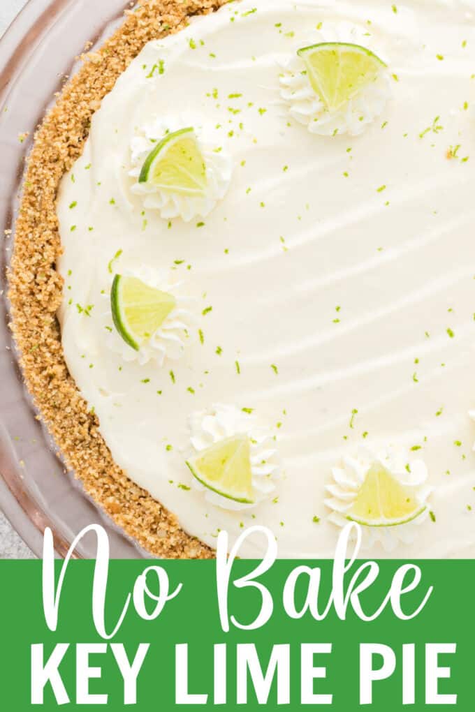 a key lime pie topped with whipped cream and limes.