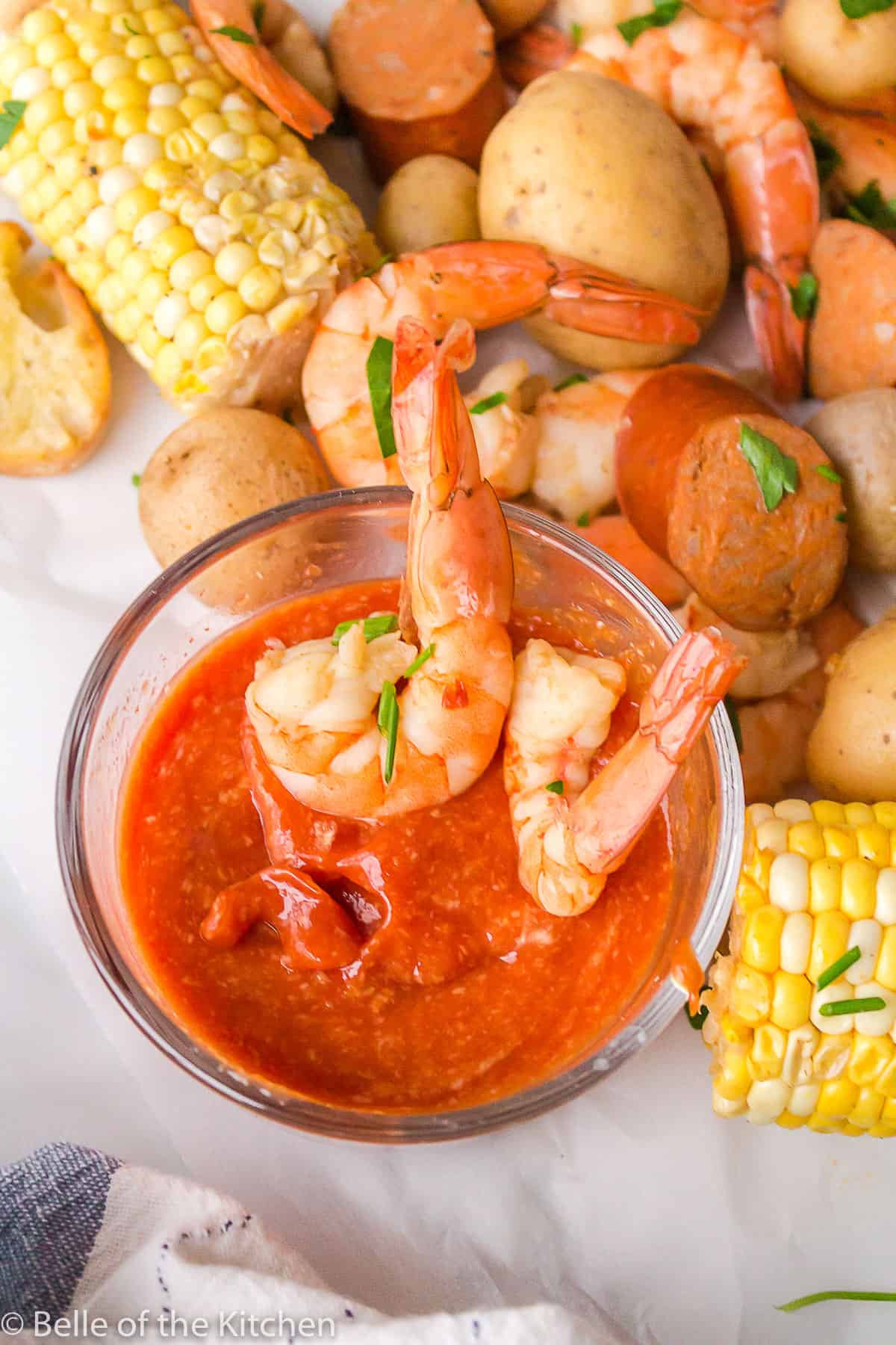 shrimp dipped into a bowl of cocktail sauce.