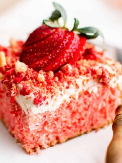a slice of cake on a plate with a strawberry on top.