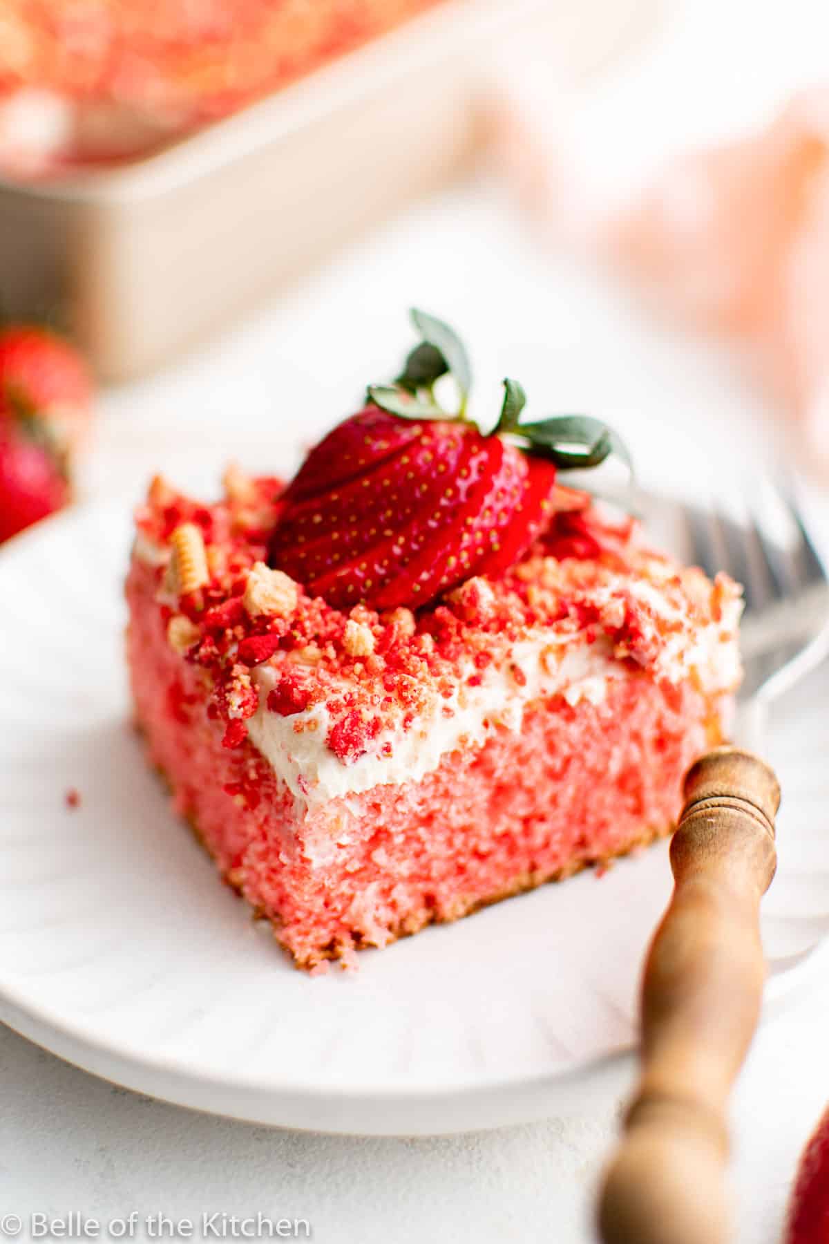 a slice of cake on a plate with a strawberry on top.