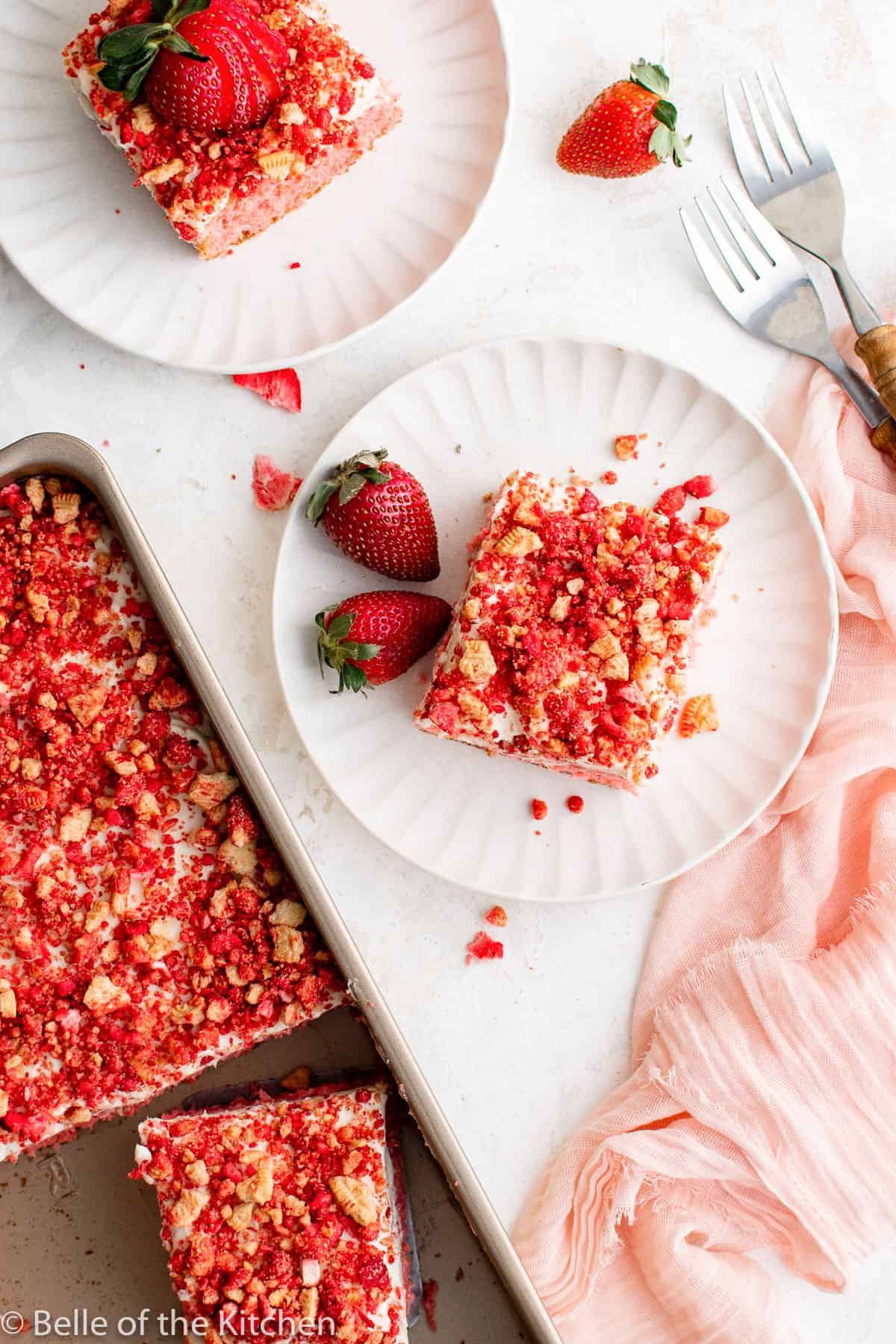 two white plates with cake and strawberries.