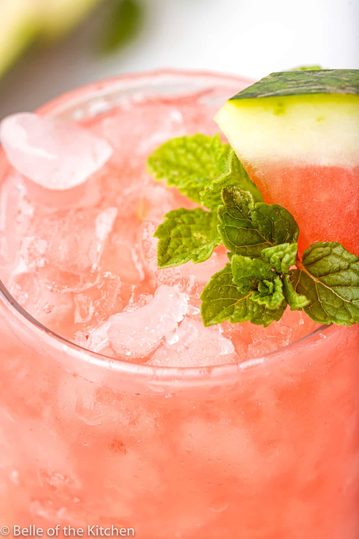 the top of a cocktail glass with ice, mint, and watermelon.