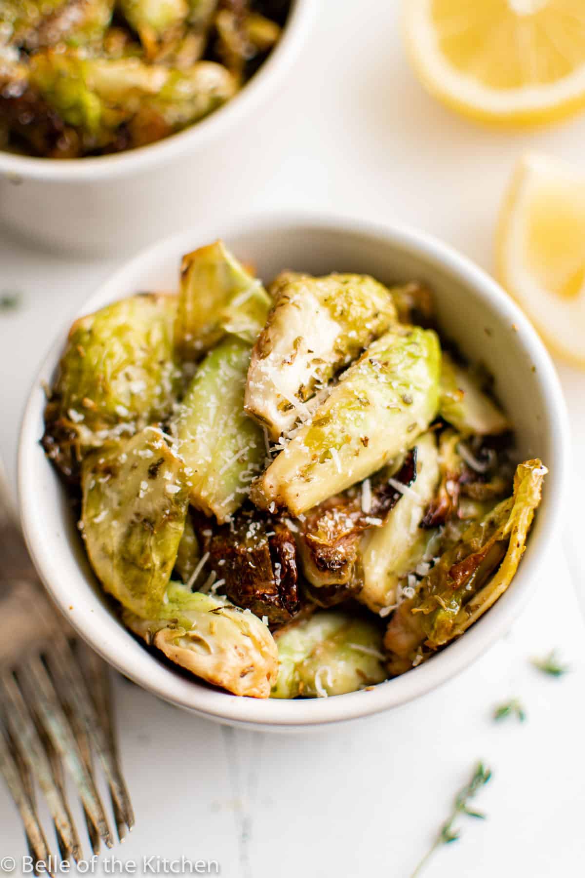 a white bowl full of Brussels sprouts.