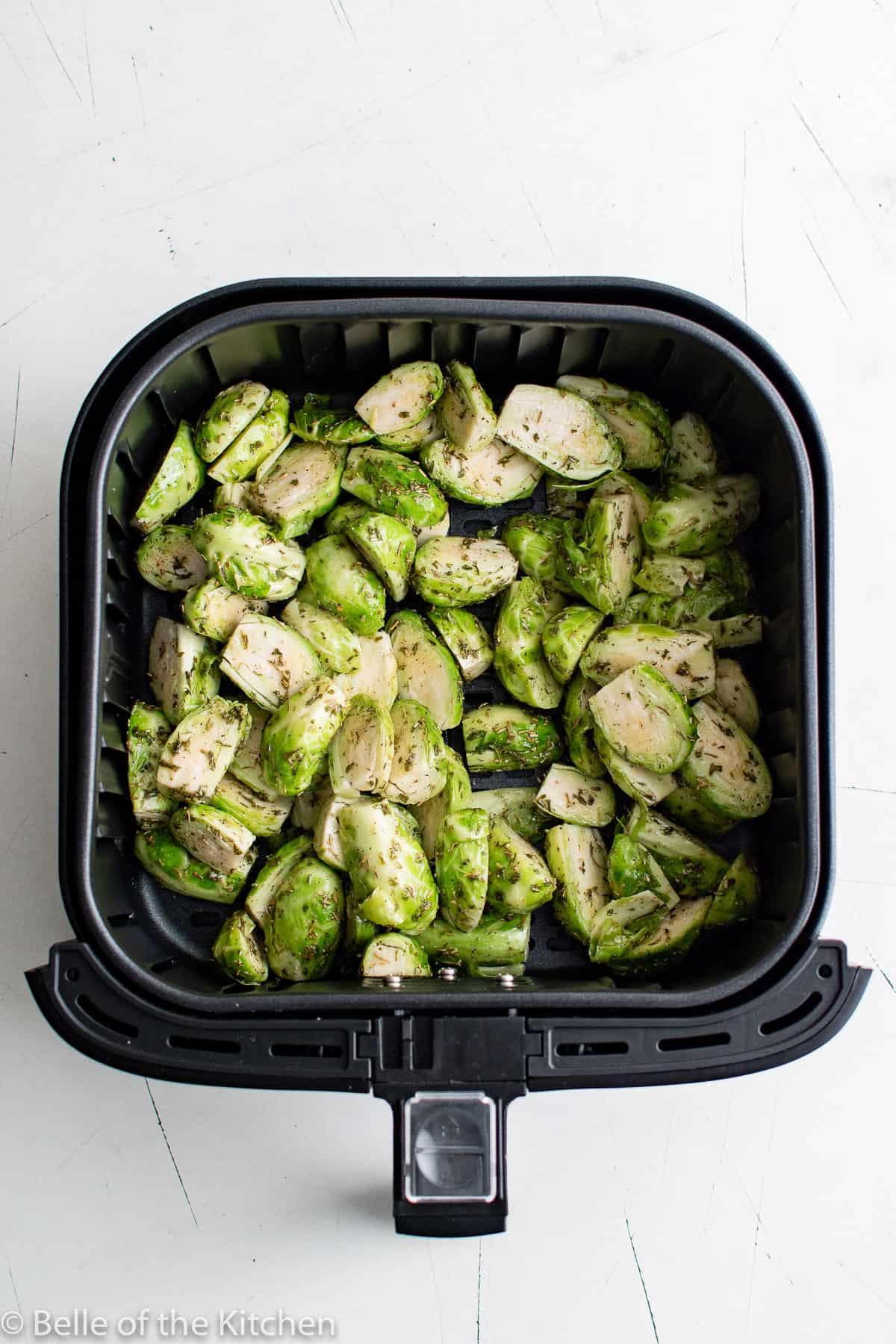 an air fryer basket full of Brussels sprouts.