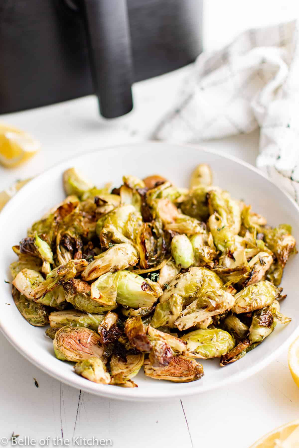 a white bowl full of Brussels sprouts.