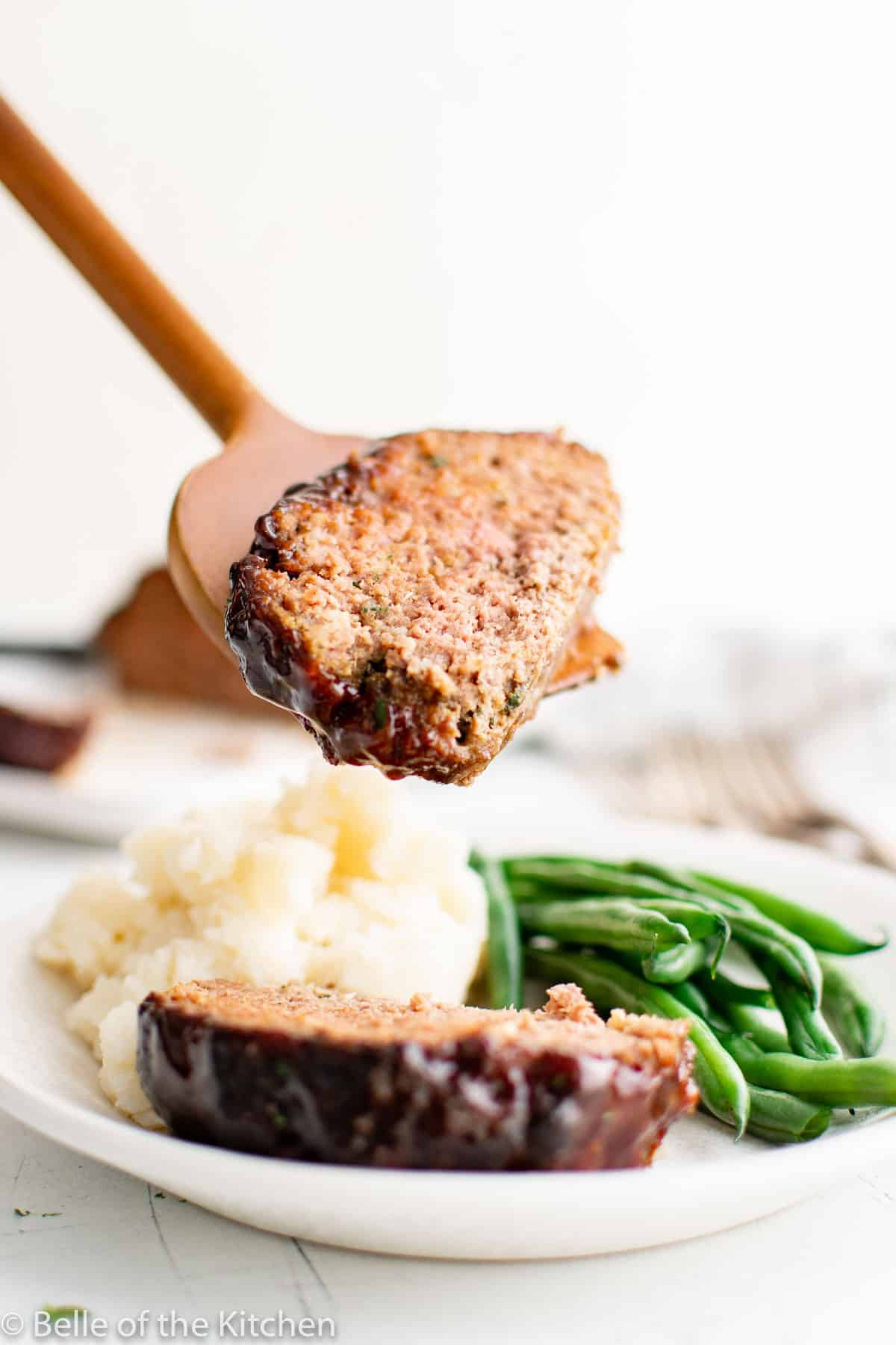 a spatula holding a slice of meatloaf.