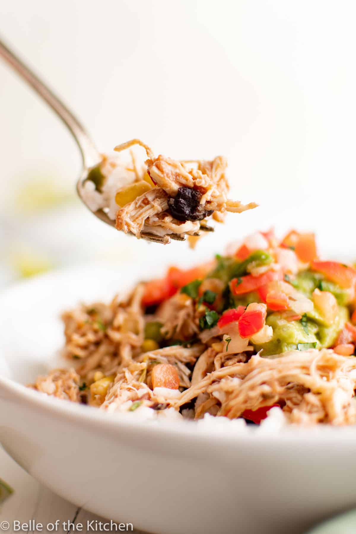 a fork dipping into a chicken burrito bowl.