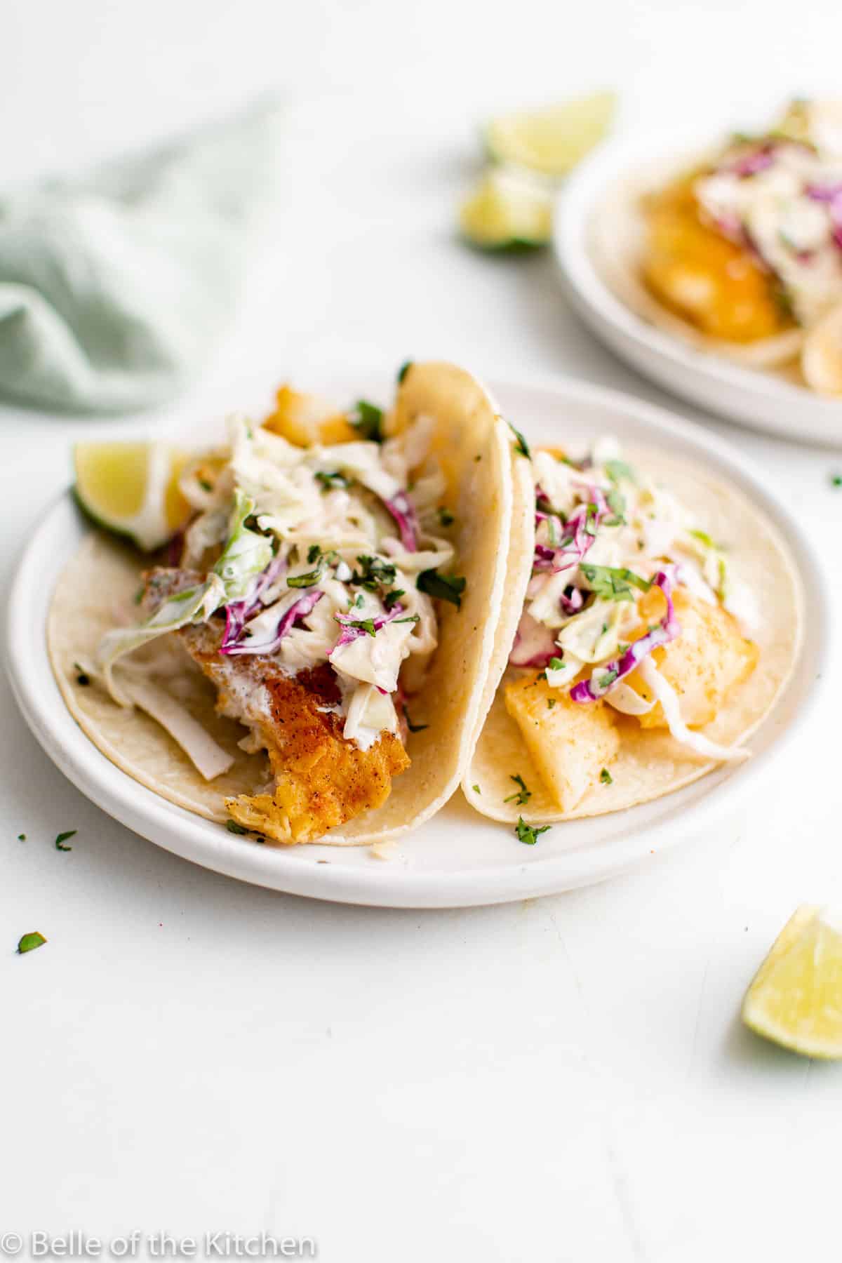close up of fish tacos with slaw on top.