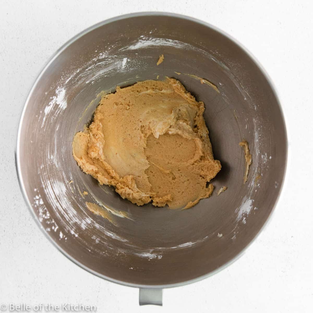 a mixing bowl with peanut butter inside.